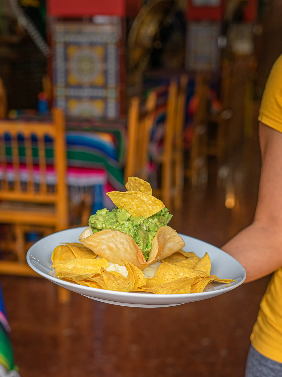 Camarera sirviendo guacamole con totopos